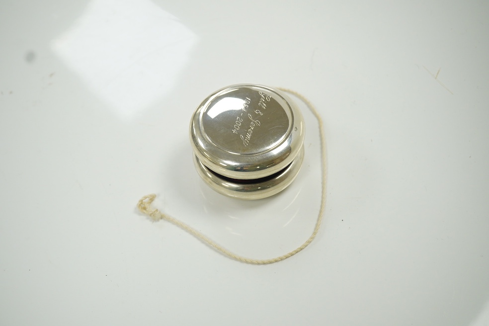 A modern silver mounted yo-yo, Practical Silverware, London, 2003, 56mm, with engraved inscription. Condition - fair to good